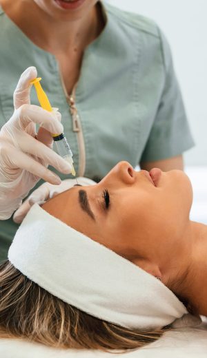 A rejuvenating shot. Woman face getting facial care by beautician hands at spa salon A rejuvenating shot. Woman face getting facial care by beautician hands at spa salon.